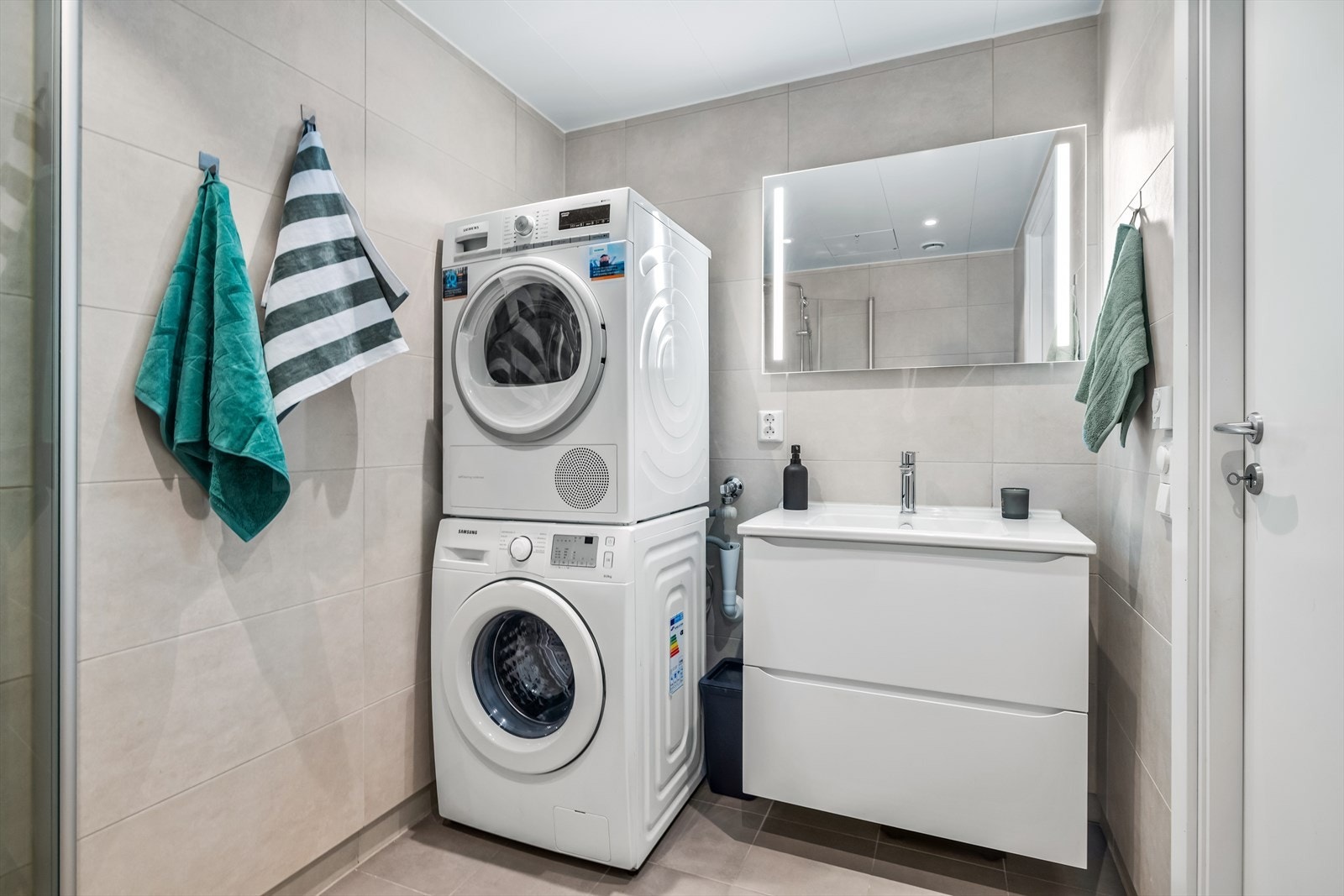 Badet har skuffeseksson, speil m/integrert lys, vegghengt wc, dusjhjørne med regnfallsdusj og opplegg for vaskemaskin. Galleribilde