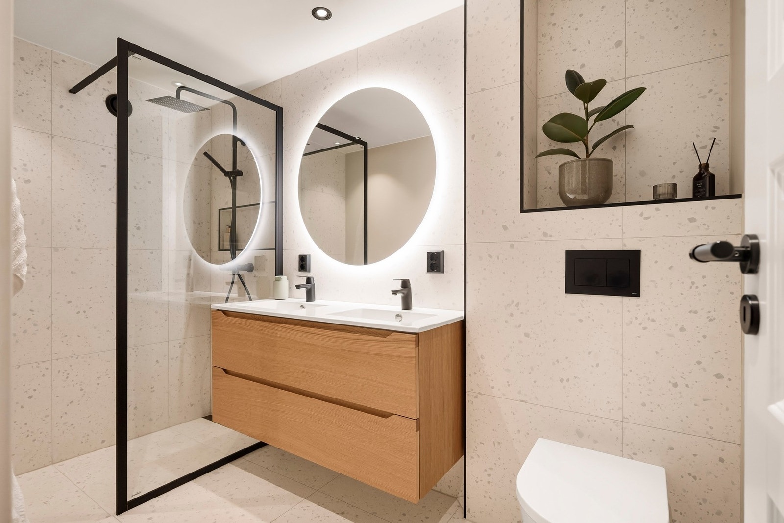 Badet har vegghengt, dobbel servantinnredning med skuffer og ovenpåliggende servant, samt speil med belysning på vegg over servant. Galleribilde