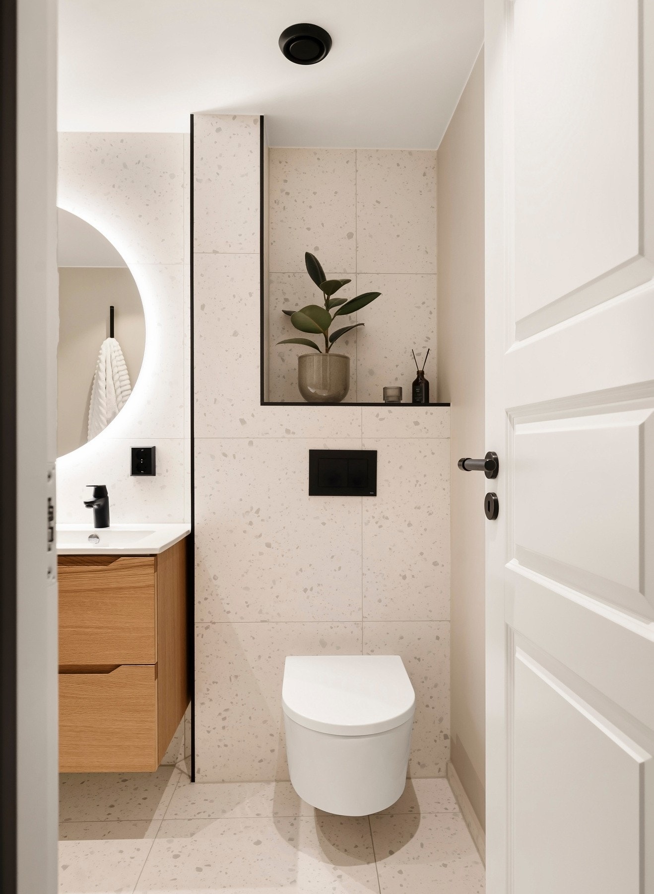 Videre inneholder badet vegghengt toalett og dusjhjørne med nisje for oppbevaring og integrert belysning, samt skillevegg av glass. Galleribilde