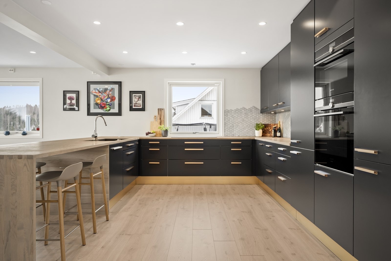 Stilrent og moderne U-formet kjøkken med rikelig skap- og benkeplass. Galleribilde