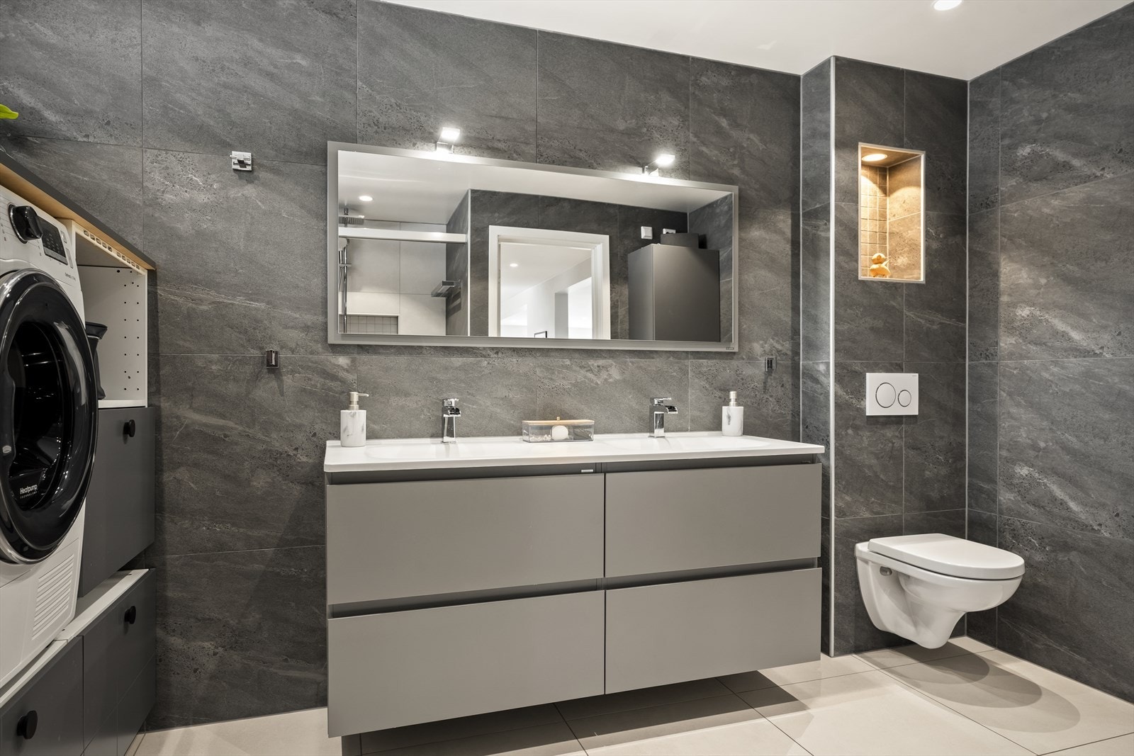 Delikat flislagt bad med moderne og gjennomført uttrykk. Galleribilde