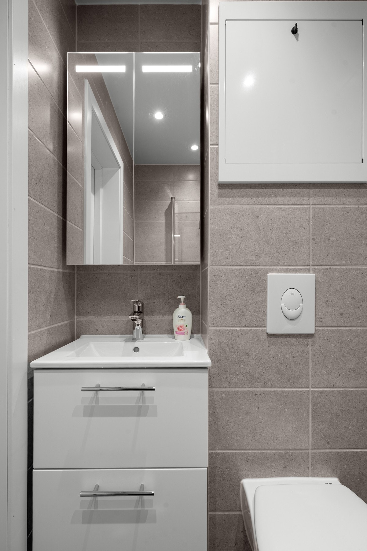 Videre er badet utstyrt med servant med innreedning, vegghengt toalett og dusj. Galleribilde