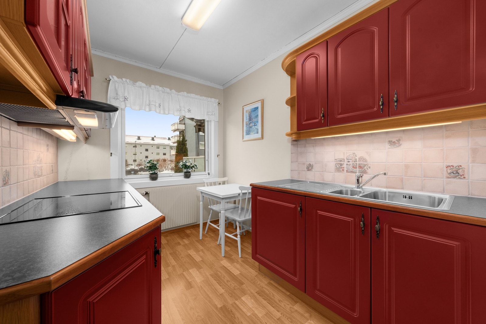 Kjøkken med eldre innredning med profilerte fronter og laminat benkeplate. Galleribilde