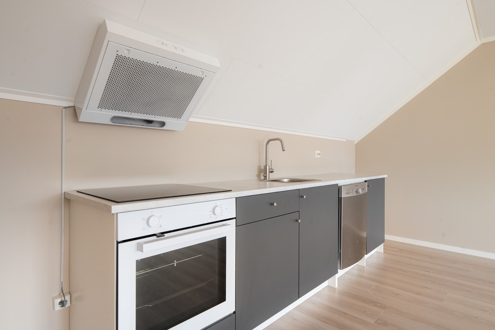 Kjøkkeninnredningen har glatte fronter, og laminert benkeplate med nedfelt oppvaskkum. Av hvitevarer er det her oppvaskmaskin, koketopp og stekeovn. Over kokesonen er det ventilator med kullfilter. Galleribilde