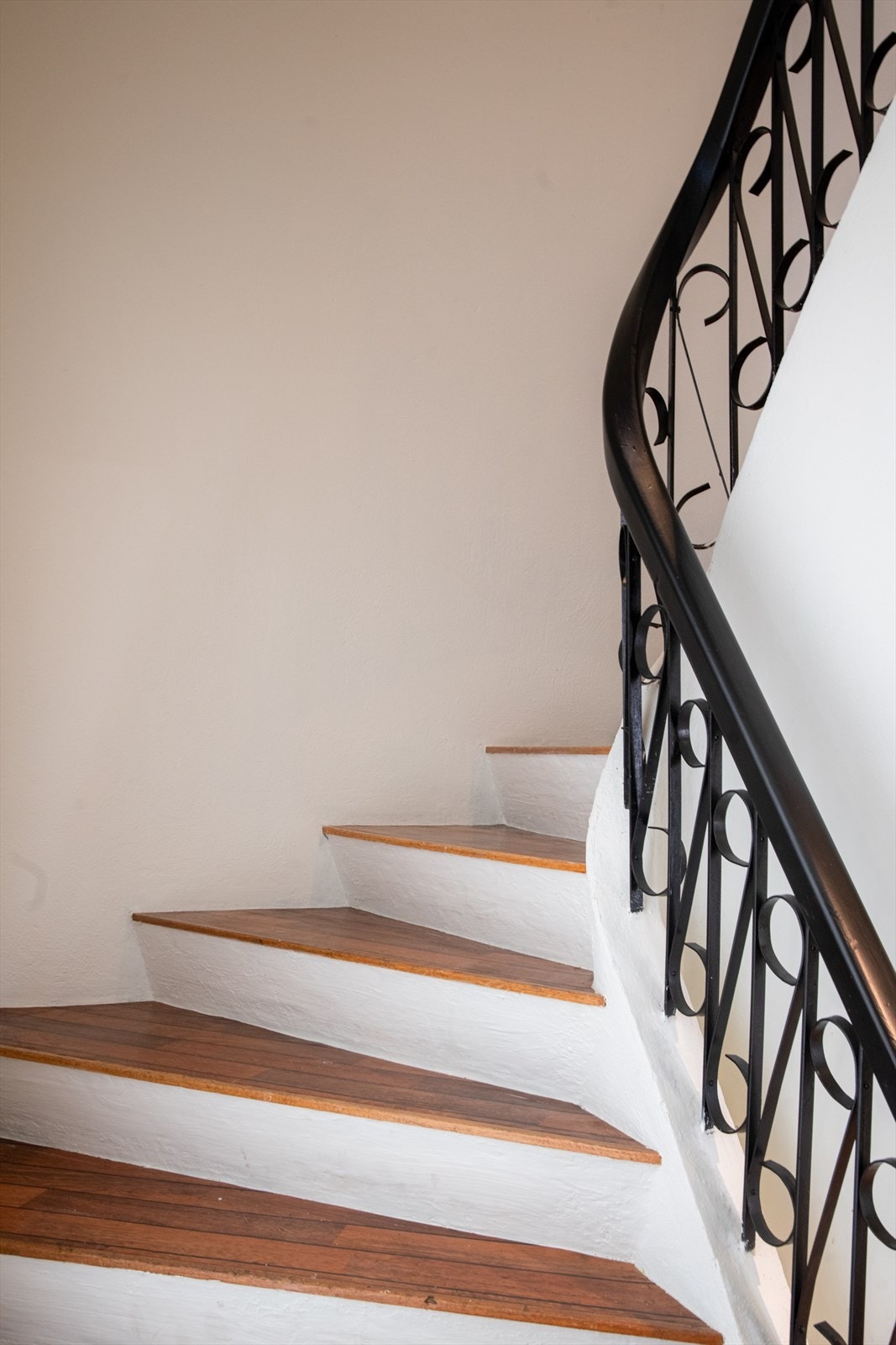 Fra gangarealer i hovedboligen er det etablert betongtrapp med gulvbelegg i trinn opp til loftetasjen. Rekkverket av tre og smijern gir trappegangen et unikt og spennende særpreg. Galleribilde