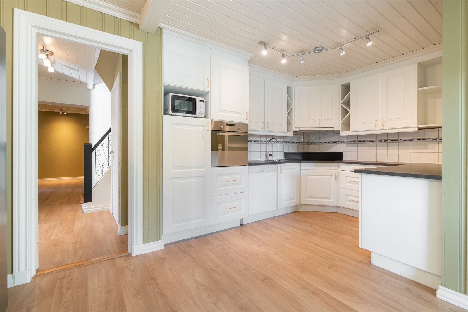 Det er god oppbevaringsplass i takhøy innredning med profilerte fronter og innslag av åpen hyller. Innredningen i heltre furu er opprinnelig fra 2007, men frontene er sprøytemalt i 2025. Galleribilde