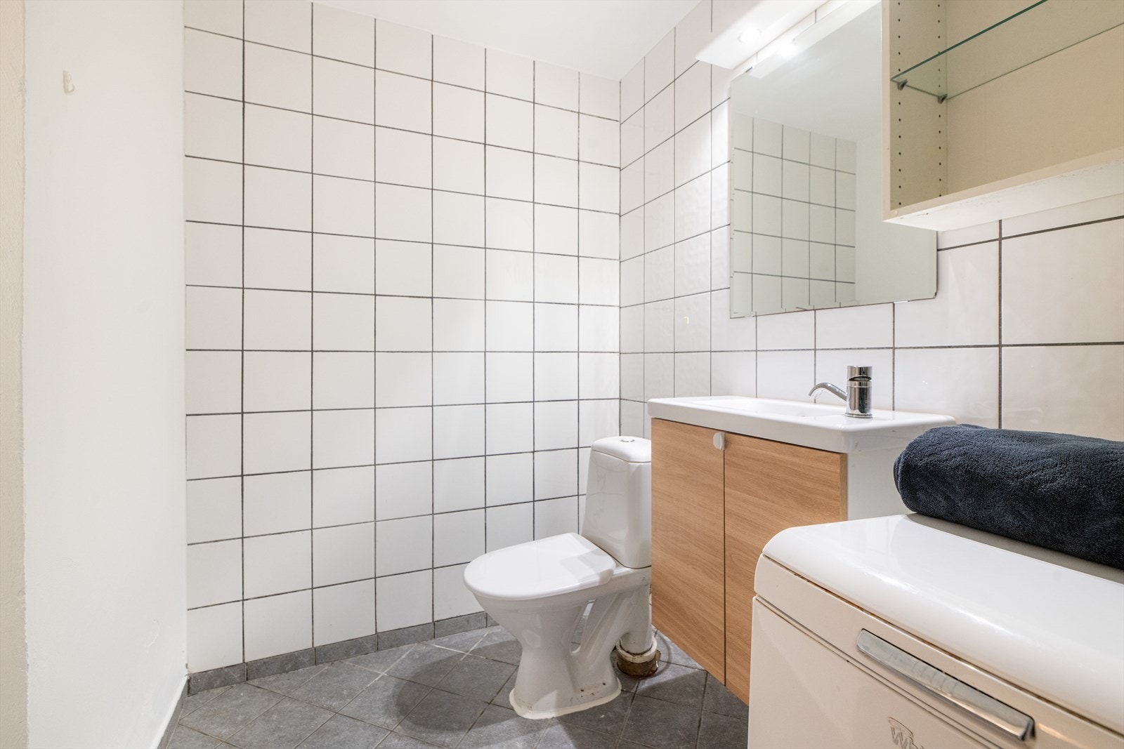 Badet i u0102 er også helfliset med varmekabler i gulvet. Også dette badet er fra 2007 og har servantskap, veggspeil, dusjkabinett og toalett. Galleribilde