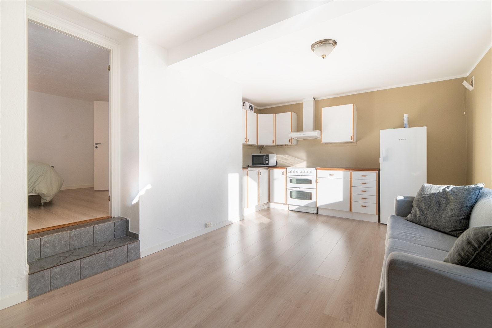 Kjøkkeninnredning med glatte fronter, og benkeplate av laminat med dobbel oppvaskkum. Hvitevarer er komfyr og kjøleskap.
Kjøkkenventilator med avtrekk ut. Galleribilde