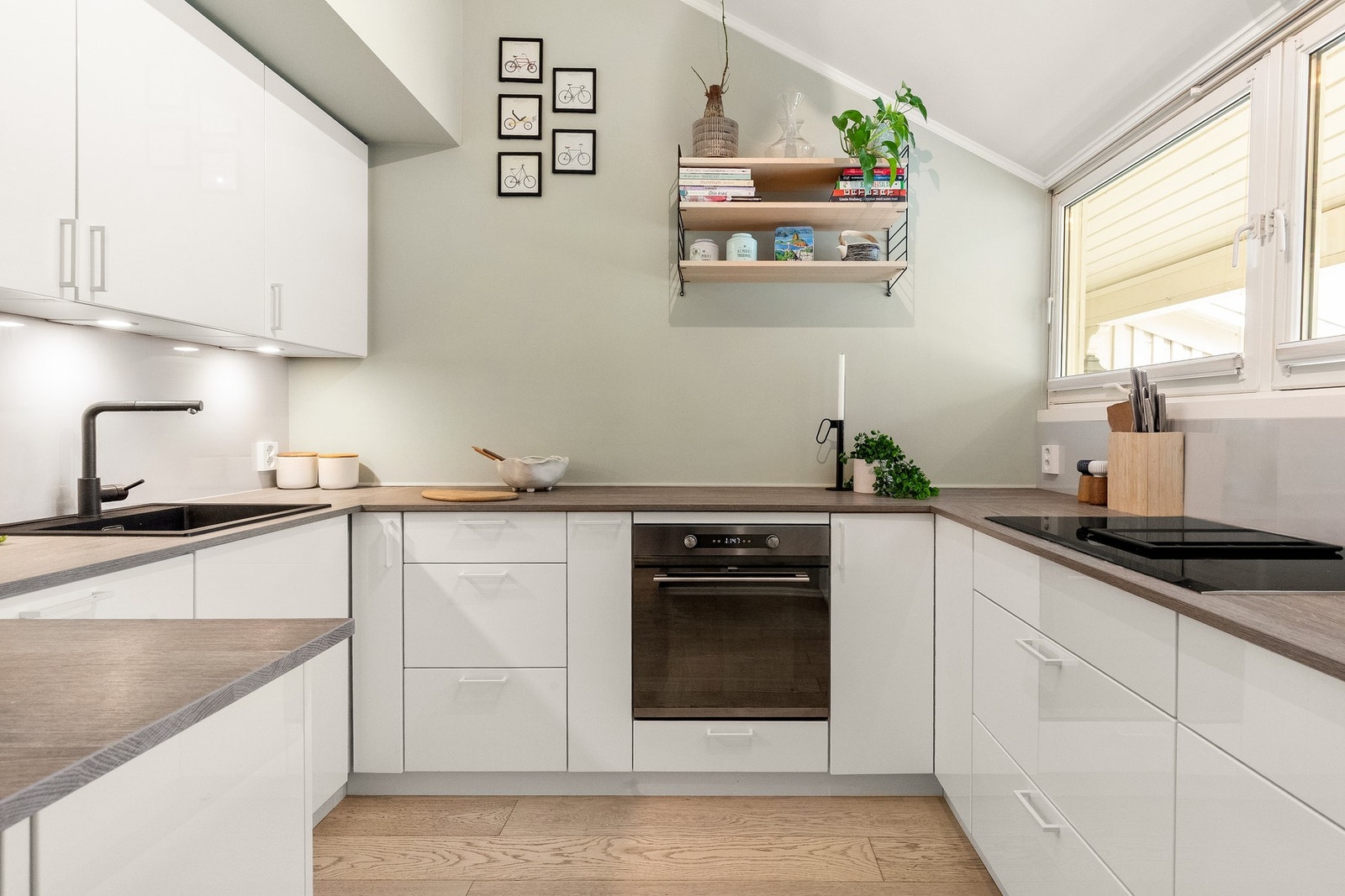 Kjøkkeninnredningen har hvite, glatte fronter og laminatbenkeplate med nedfelt kum i sort kompositt. Galleribilde