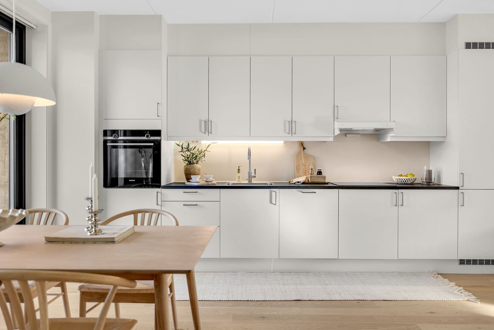 Pent og tidsriktig kjøkken med glatte fronter og benkeplate i laminat. Galleribilde