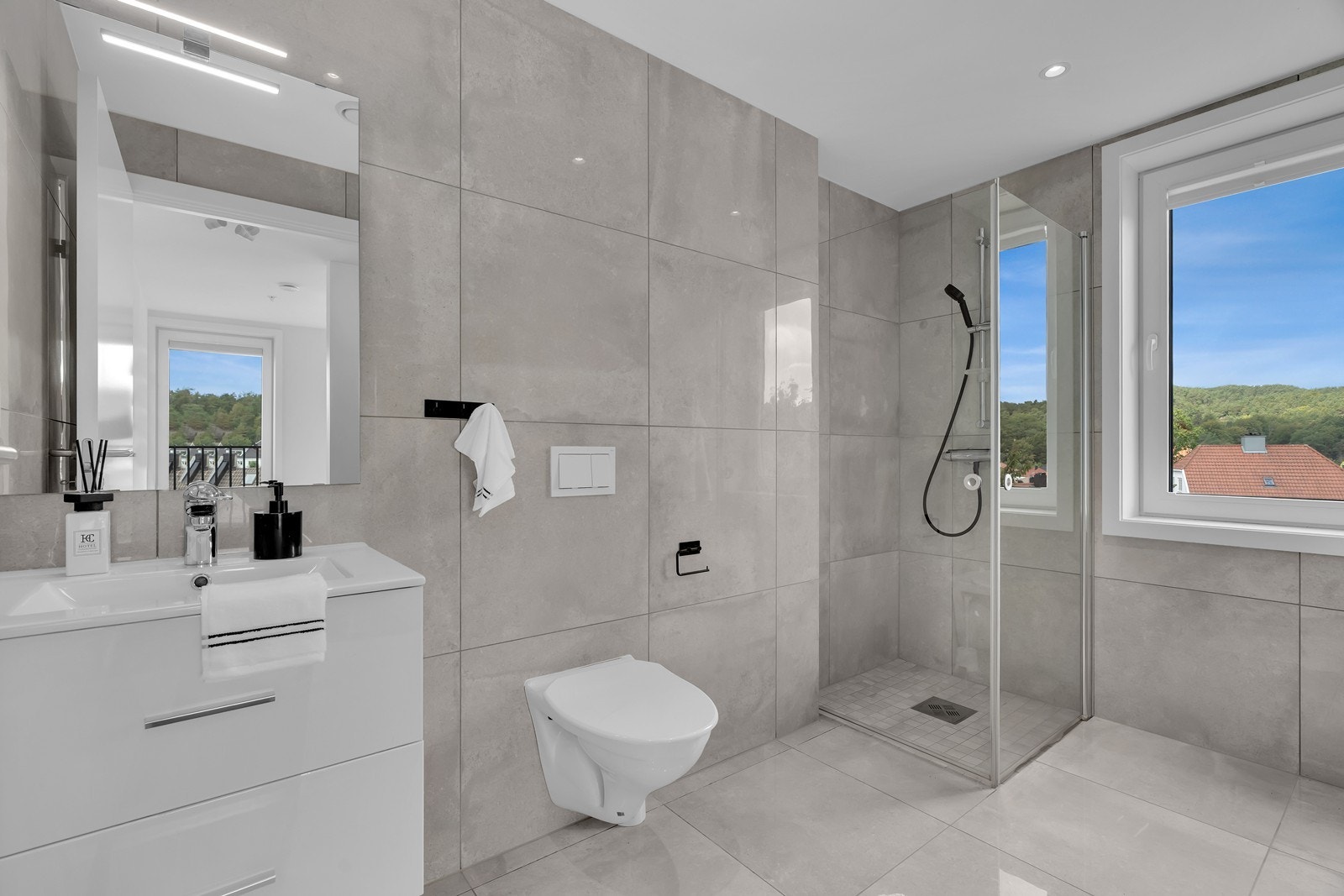 Pent flislagt bad med fine løsninger Galleribilde