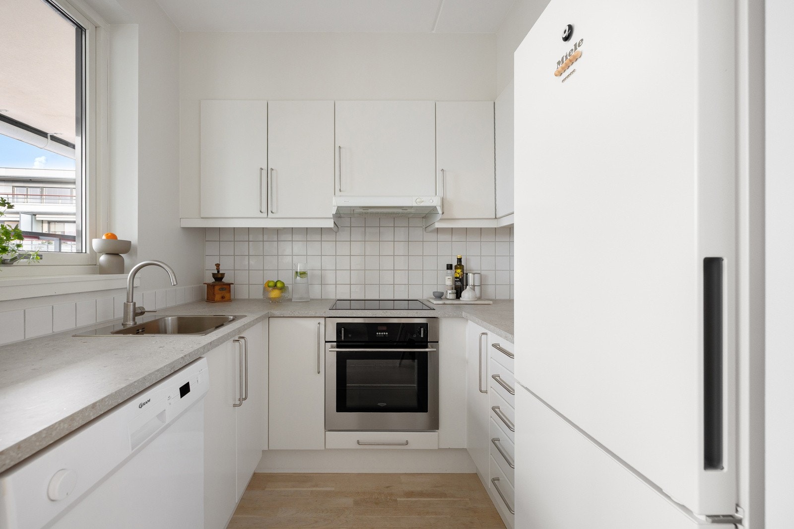 Stilren innredning fra Sigdal med hvite fronter og hvitevarer som medfølger. Galleribilde