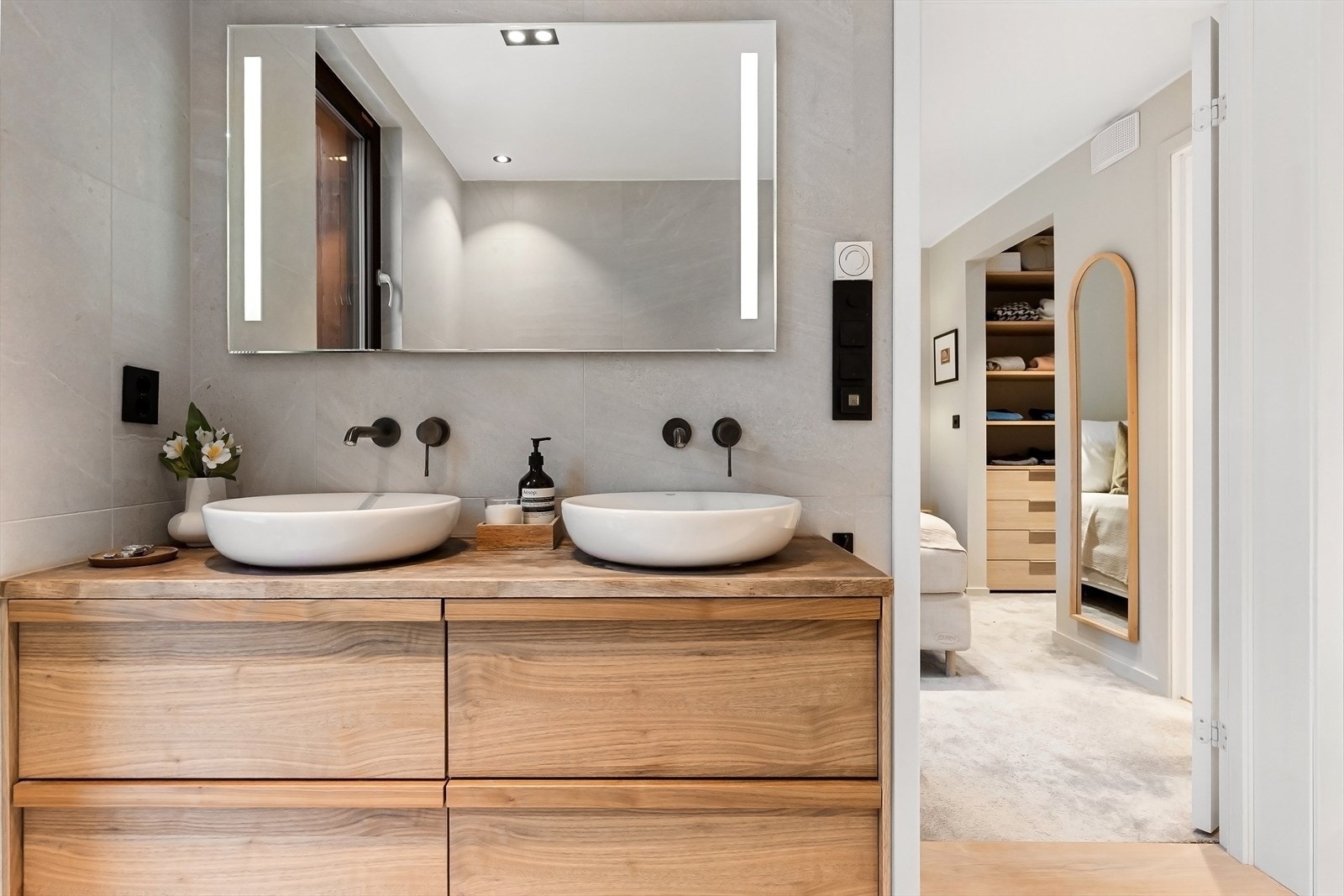 Servantskap med glatte fronter og servantbolle på benk. Speil med integrert belysning. Galleribilde