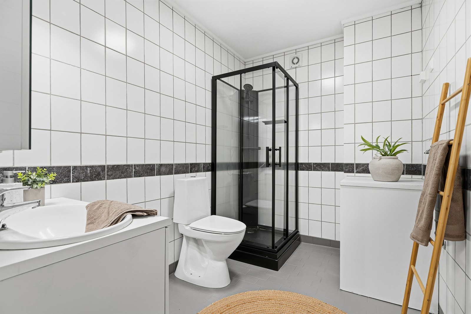 Flott baderom bestående av gulvstående toalett, dusjkabinett og baderomsinnredning. Galleribilde