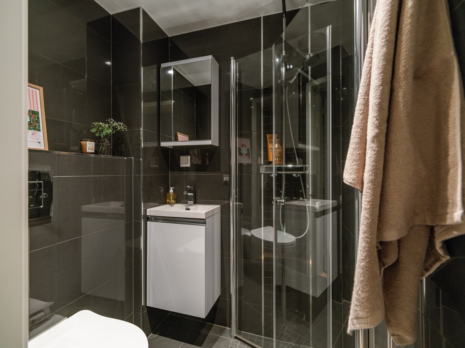 Baderommet har flislagte vegger og gulv. Pusset opp av tidligere eier i 2019. Baderomsinnredning med servant på underskap og speilskap over. Galleribilde