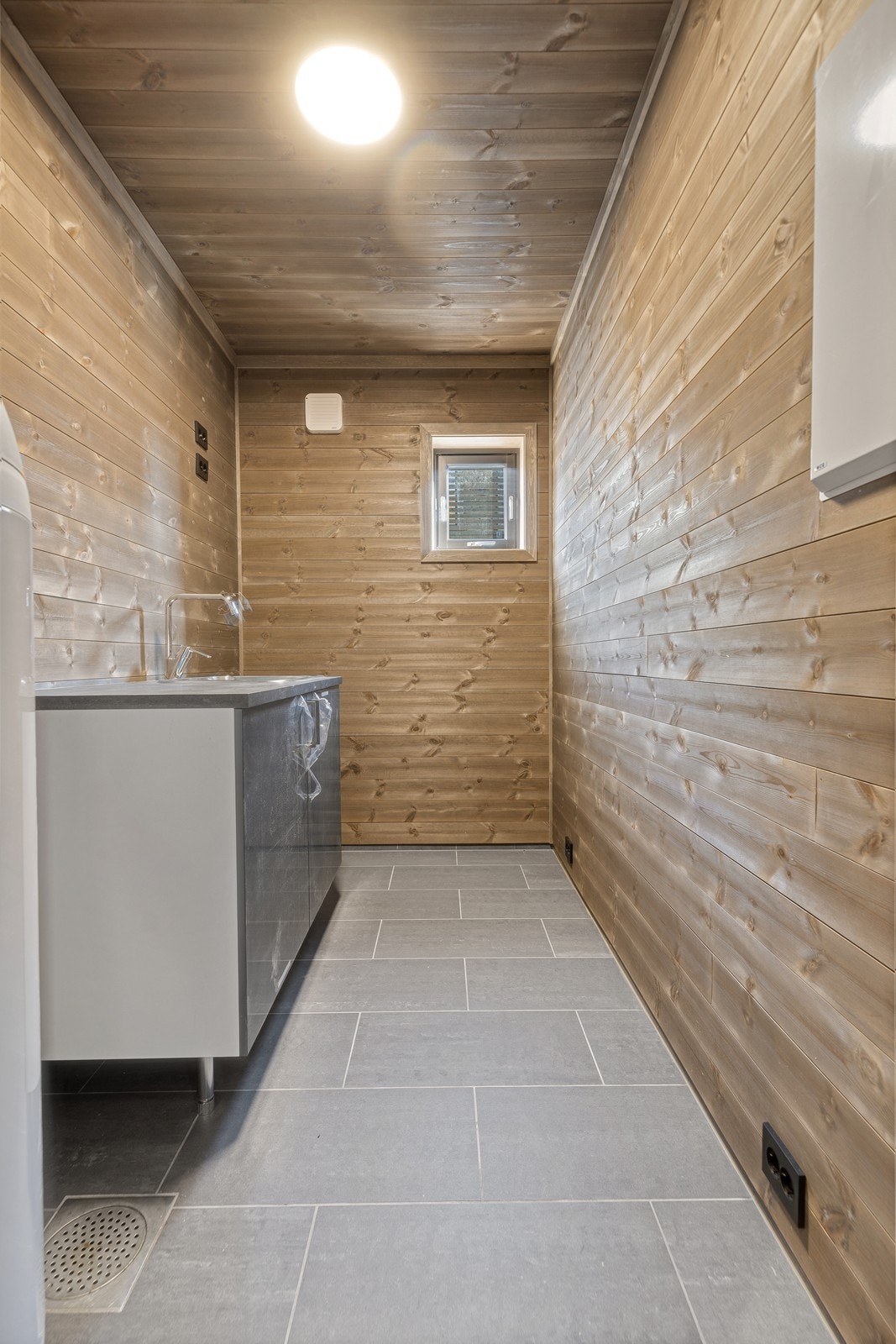 Praktisk vaskerom i samme utførelse som badet. Her har du en enkel innredning m/utslagsvask og god plass til vaskemaskin/tørketrommel Galleribilde