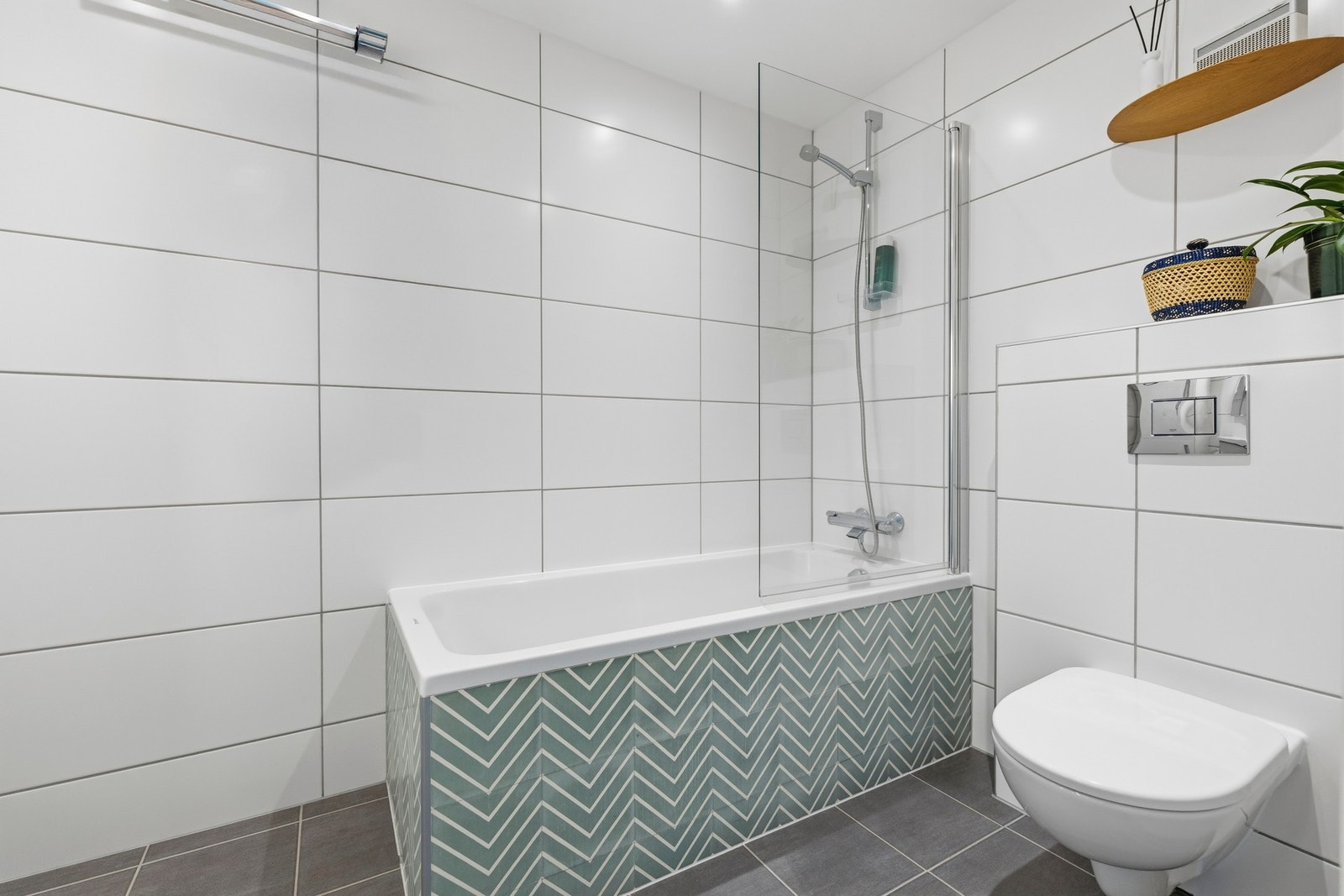 Innredningen består av skap med glatte fronter, servant, veggfestet klosett og et innmurt badekar Galleribilde