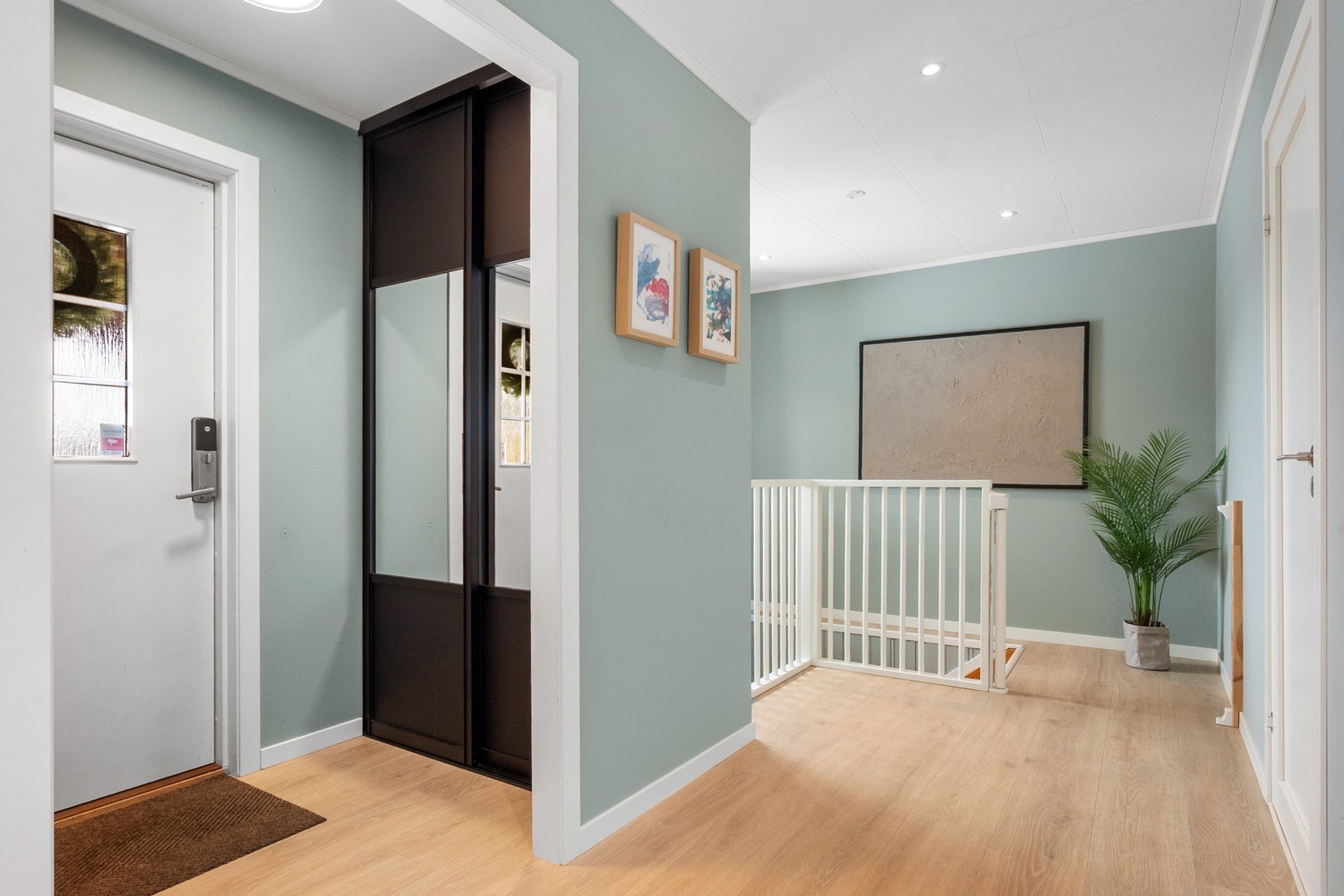 Yttertøy og sko oppbevares enkelt i skyvedørsgarderobe som glir sømløst inn uten å ta unødvendig mye plass. Det er montert Yale Doorman lås, og fra entréen er det trapp ned til underetasjen Galleribilde