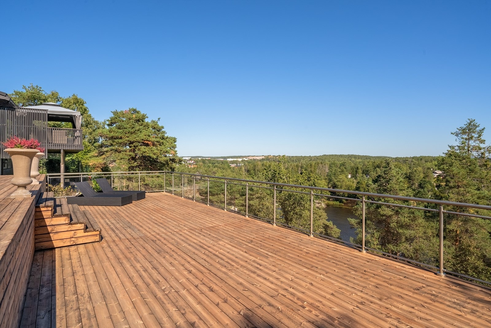 Stor og solrik terrasse med flott utsikt over Vansjø og omkringliggende natur. Den romslige utformingen gir rikelig med plass til både sittegrupper, solsenger og sosiale sammenkomster. Foto: Studio Eik Galleribilde