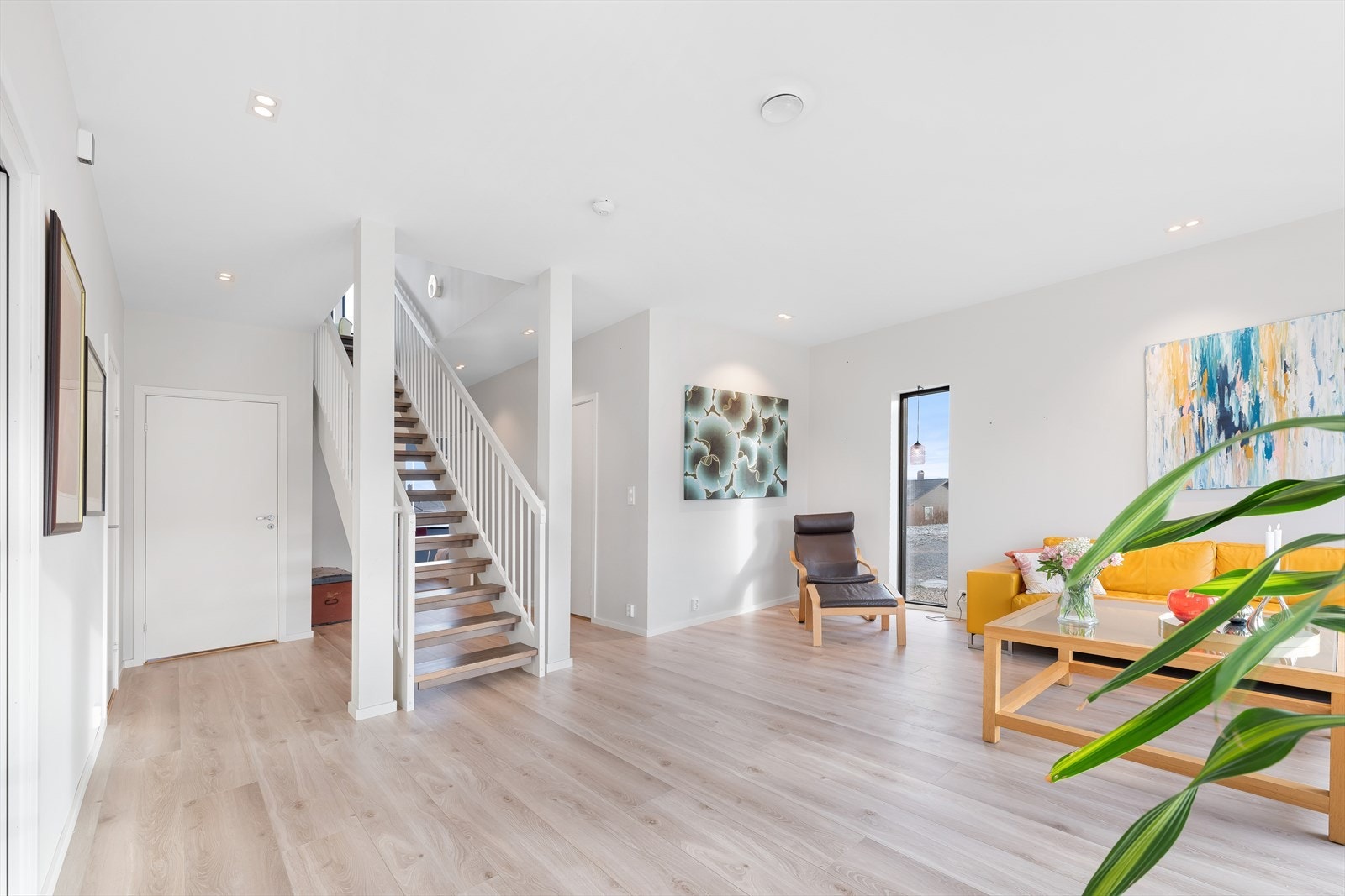 Fra gangen kommer du inn i en lys og romslig stue med heltre trapp opp til 2. etasje. Galleribilde