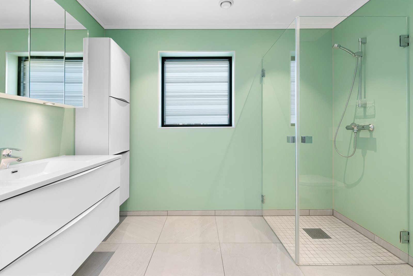 Bad med fliser på gulv og våtromsplater på vegg. Varmekabler i gulv. Galleribilde