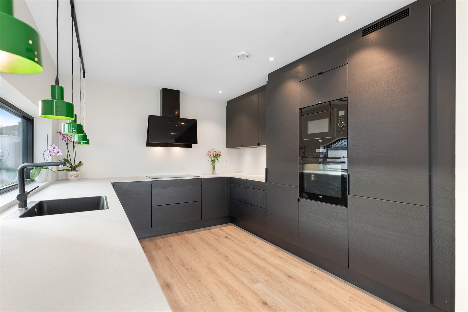 Stilfult kjøkken med glatte fronter. Benkeplate med nedfelt vask og platetopp. Innredningen innehar steikeovn, micro, oppvaskemaskin og kjøleskap/frys. Galleribilde