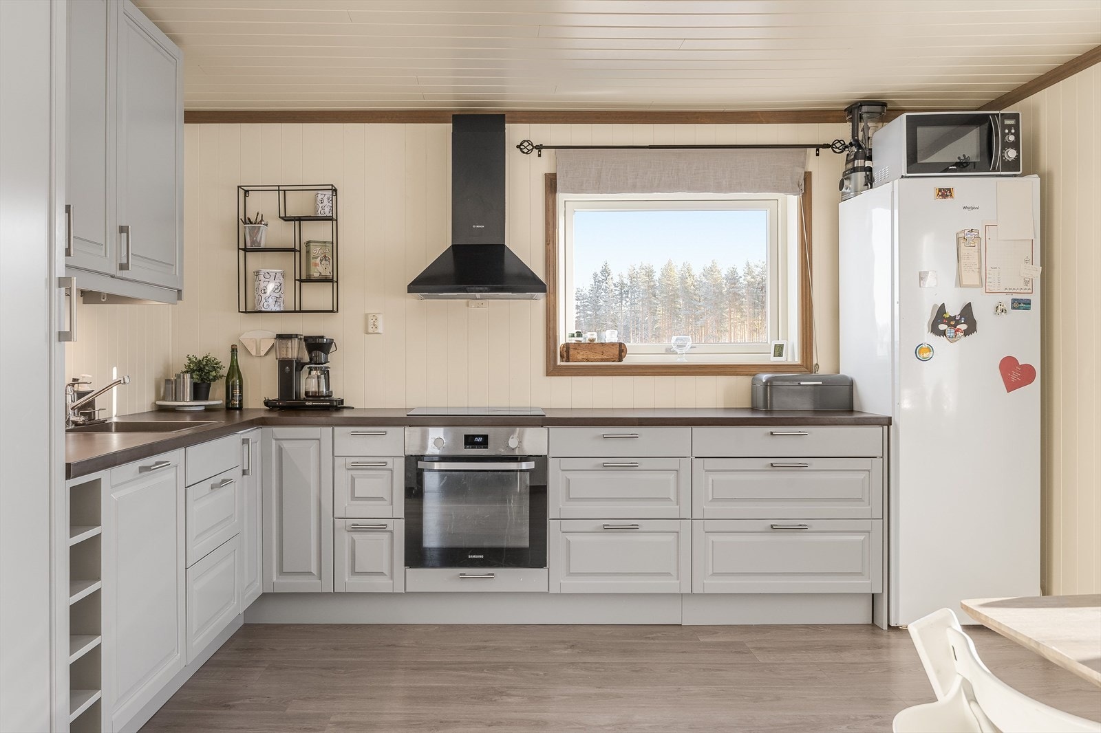 Pent, stilrent kjøkken med integrerte hvitevarer som stekeovn og koketopp. Frittstående løsning for kjøleskap/frys. Galleribilde