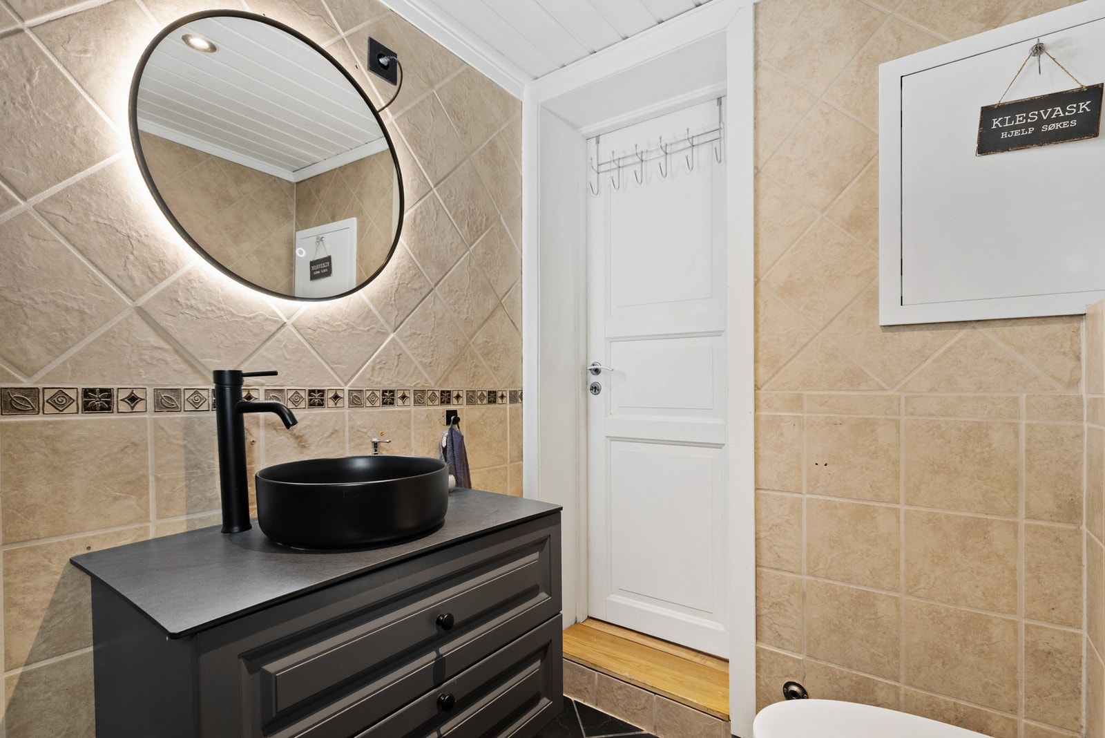 Badet er innredet med dusjkabinett og baderomsinnredning fra 2023 med bollevask og speil med integrert belysning. Galleribilde