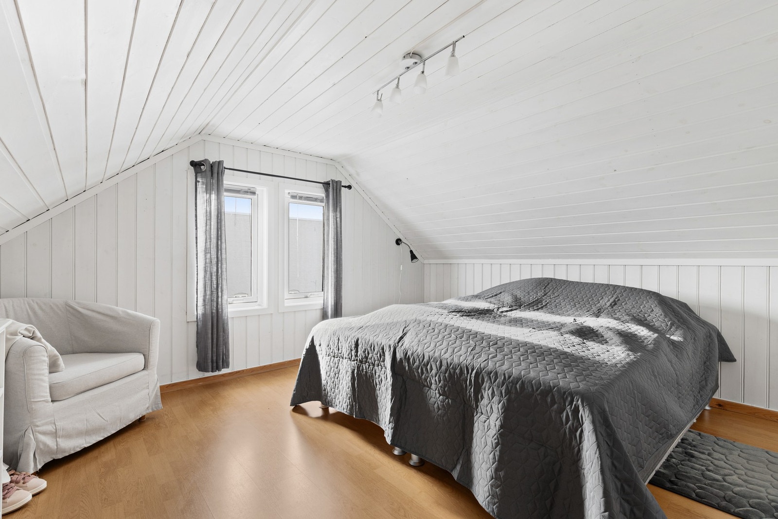 Lyst og romslig soverom med fin plass til dobbeltseng, nattbord og øvrig møblement Galleribilde