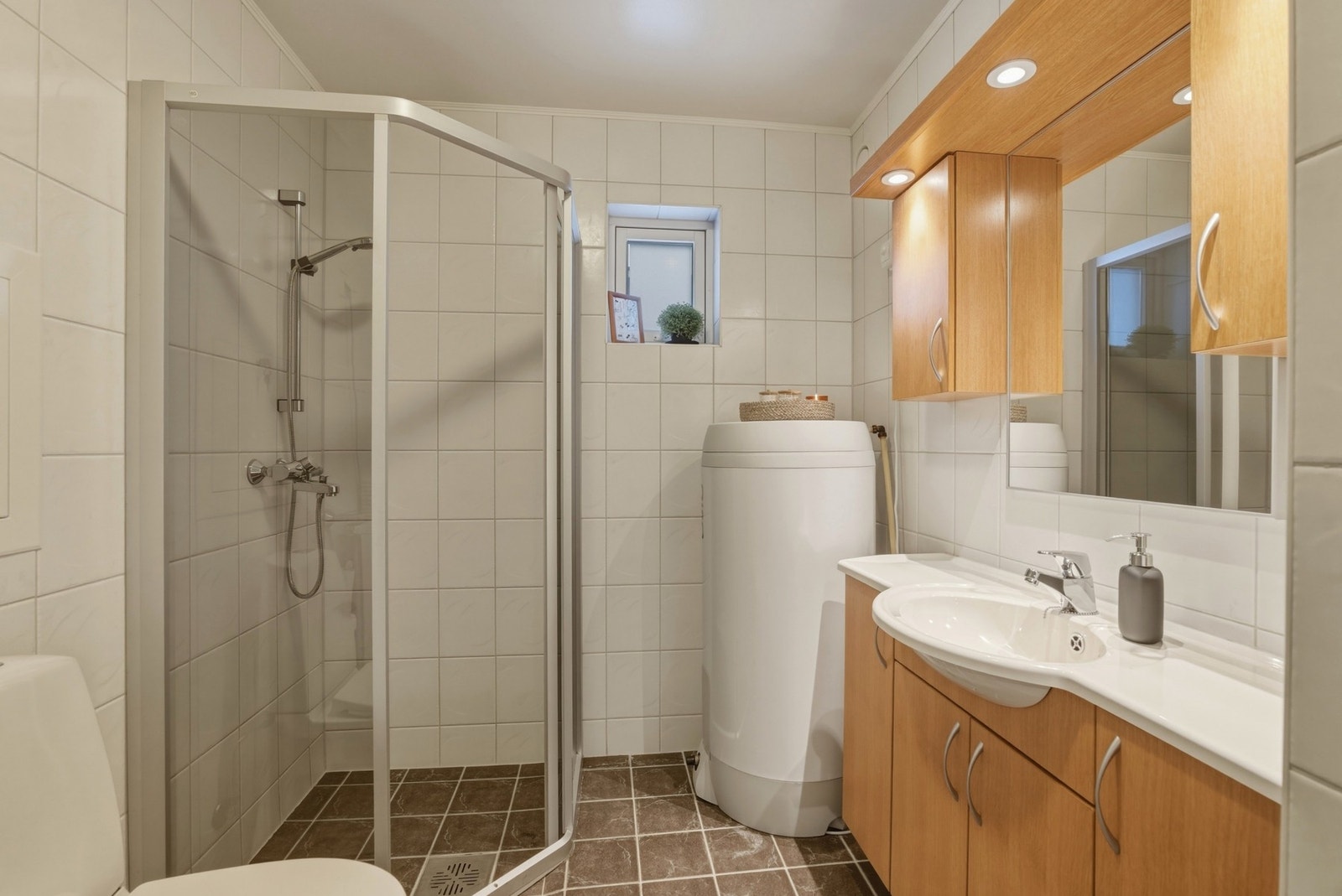 Flislagt bad i tidløs utførelse med varme i gulv. Dusjhjørne med glassvegger. Ny VVB i 2022. Gulvstående toalett. Galleribilde