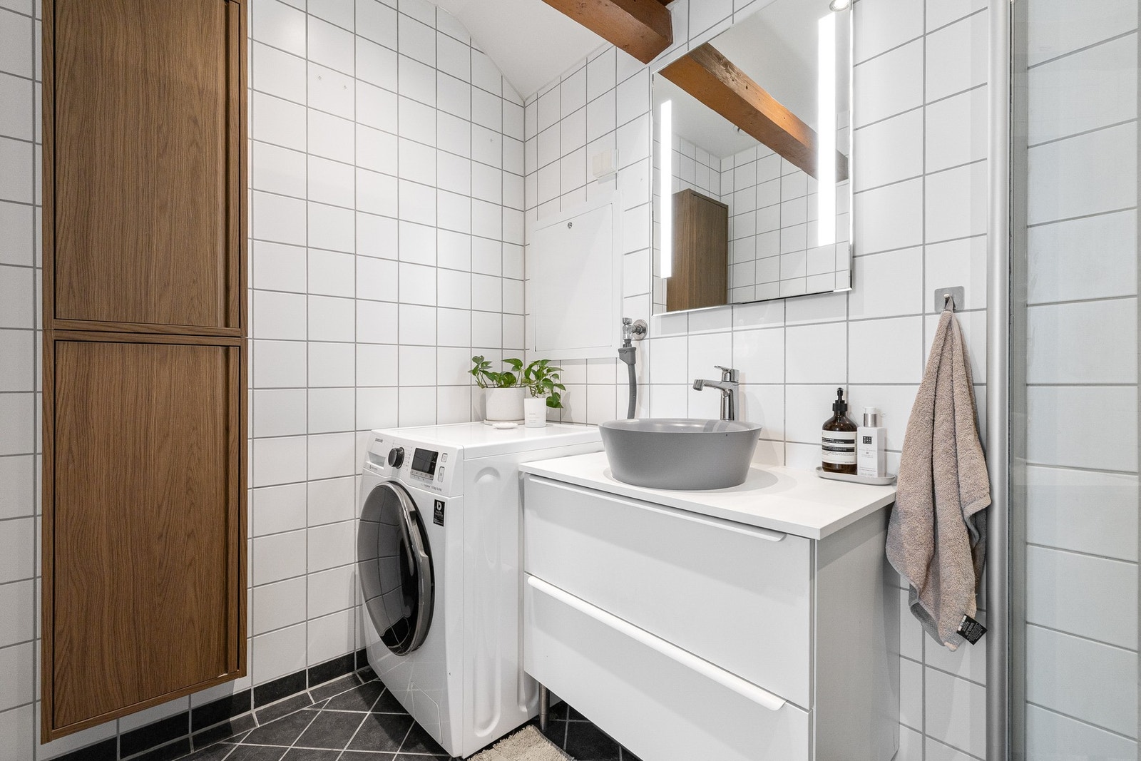 Godt utnyttet bad med praktisk oppbevaring, opplegg for vaskemaskin og moderne servantløsning. Galleribilde