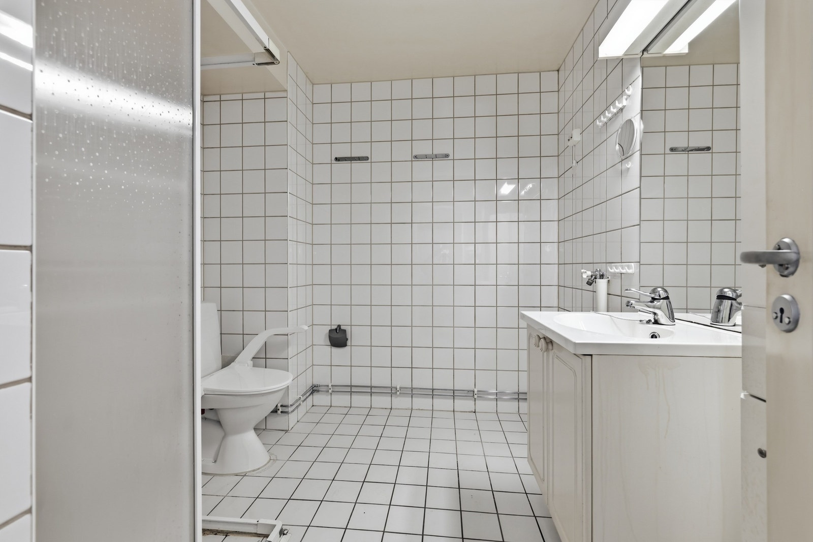 Badet er helfliset og utstyrt med dusjhjørne og servantinnredning. Galleribilde