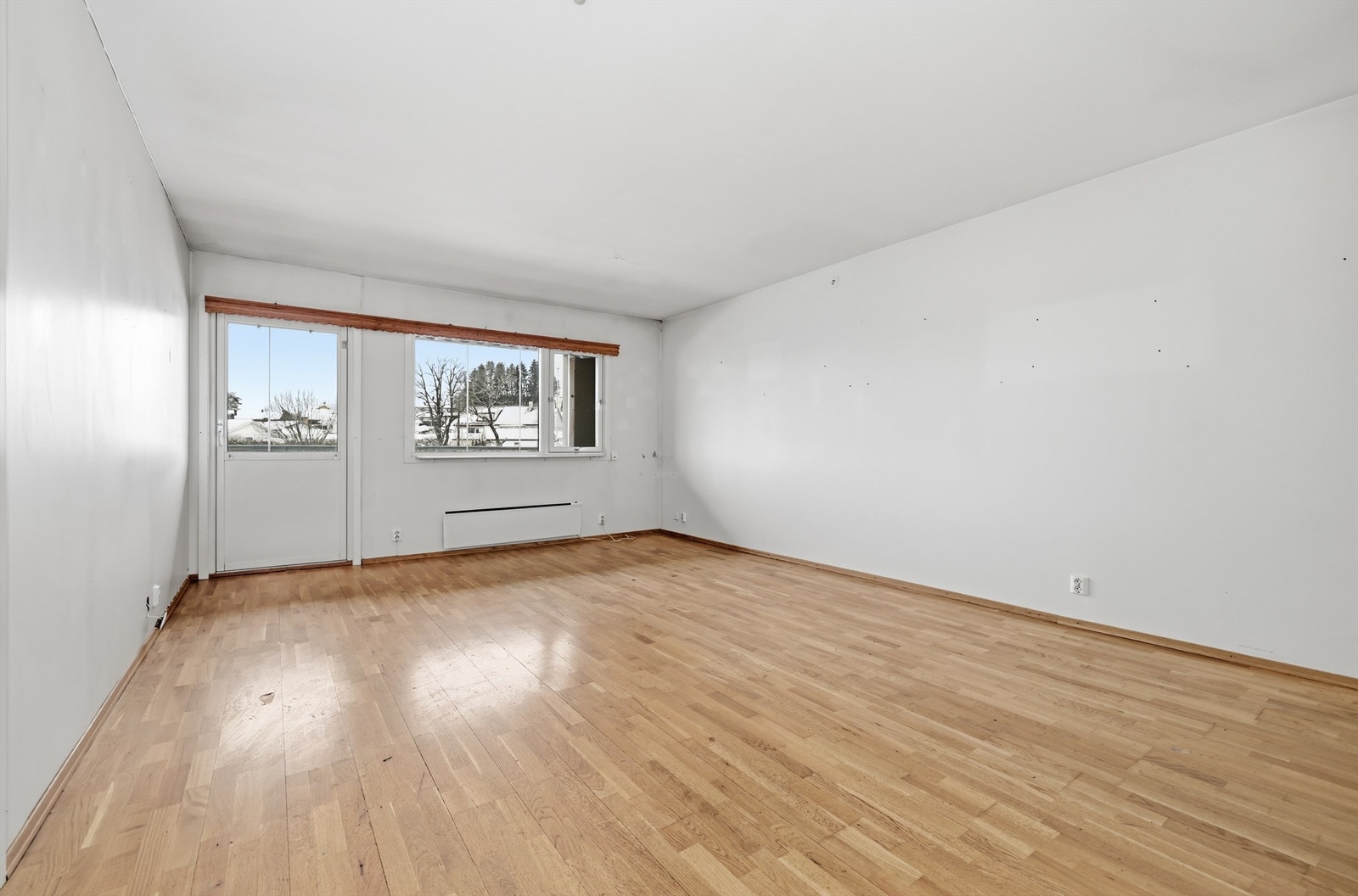 Stuen er et lyst og åpent rom med utgang til leilighetens balkong. Galleribilde