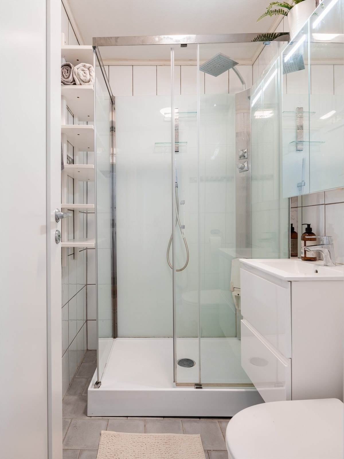 Badet er flislagt og ble i 2020 oppgradert med nytt dusjkabinett, servant med skap og speilskap. Galleribilde