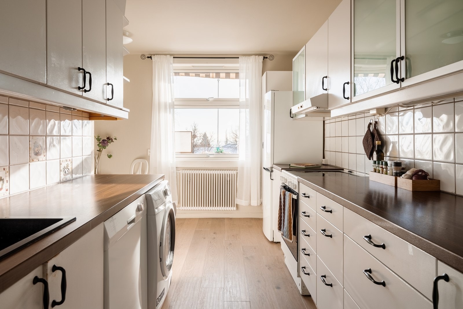 Praktisk kjøkken med innredning med glatte fronter og laminatbenkeplate. Galleribilde