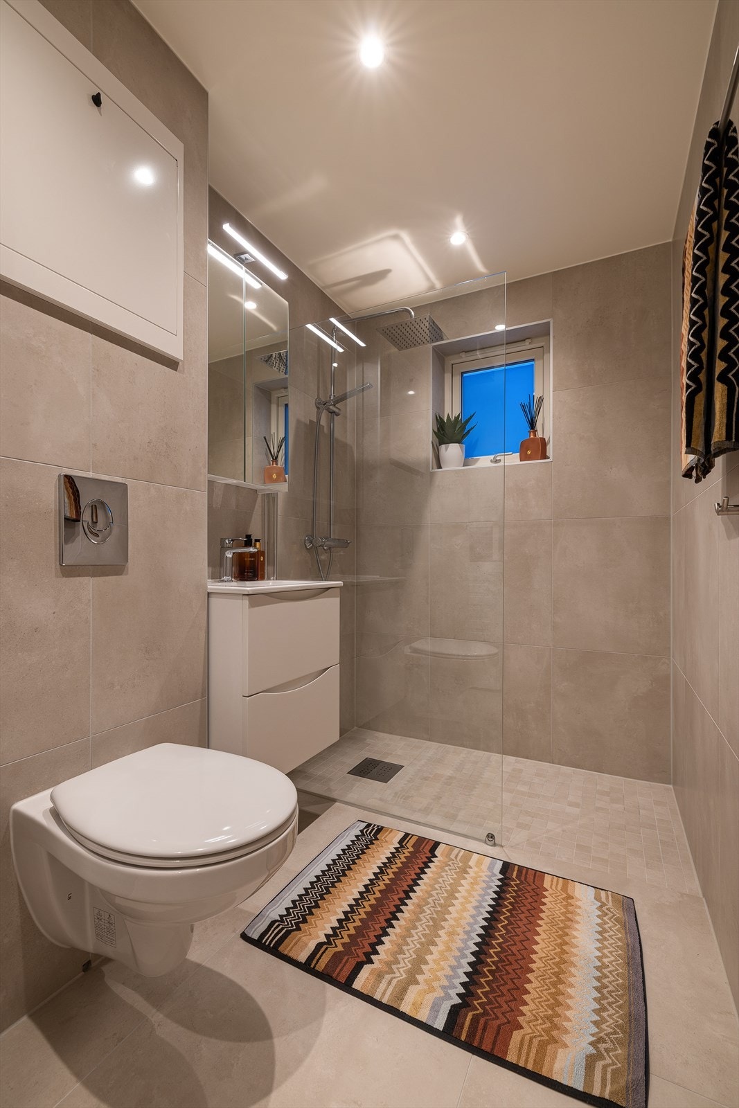 Her er det flislagt gulv med varmekabler og et dusjhjørne med glassvegg. Galleribilde