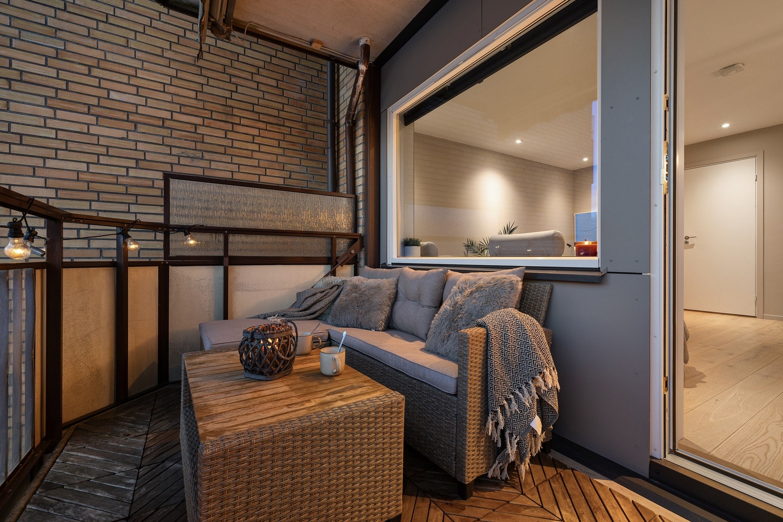 Balkongen er belagt med terrassefliser av tre og har plass til en utendørs sittegruppe. Galleribilde