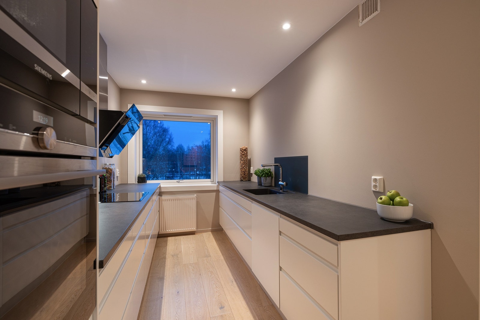 Kjøkkeninnredningen fra Norema har glatte fronter og benkeplate i laminat. Galleribilde