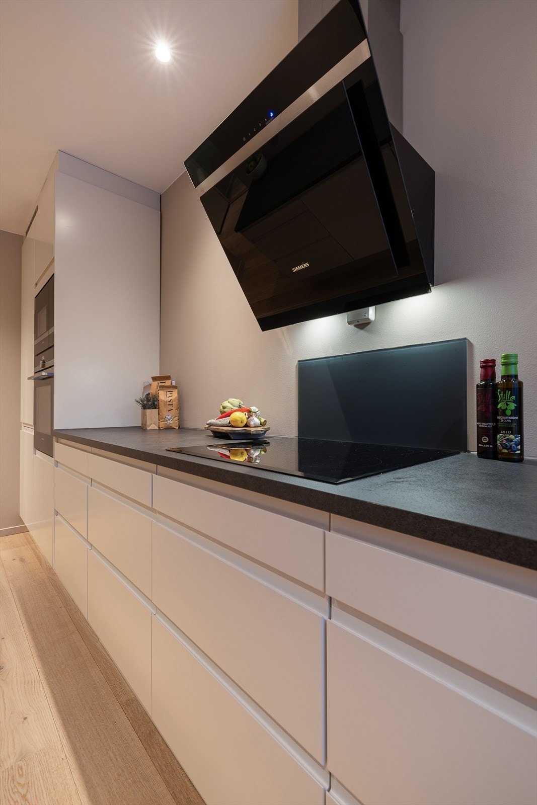 Kjøkkenet er utstyrt med komfyrvakt, vegghengt ventilator, integrerte hvitevarer og god benkeplass. Galleribilde