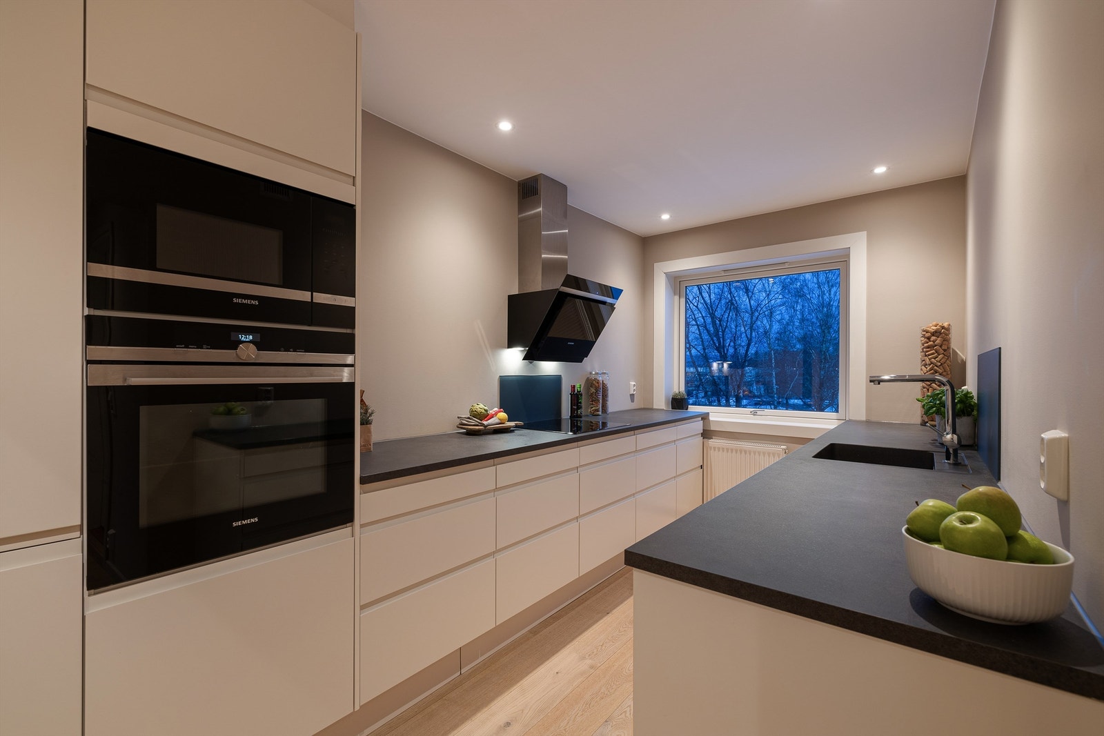 Kjøkken med moderne uttrykk og løsning uten overskap som gir et luftig og ryddig preg Galleribilde