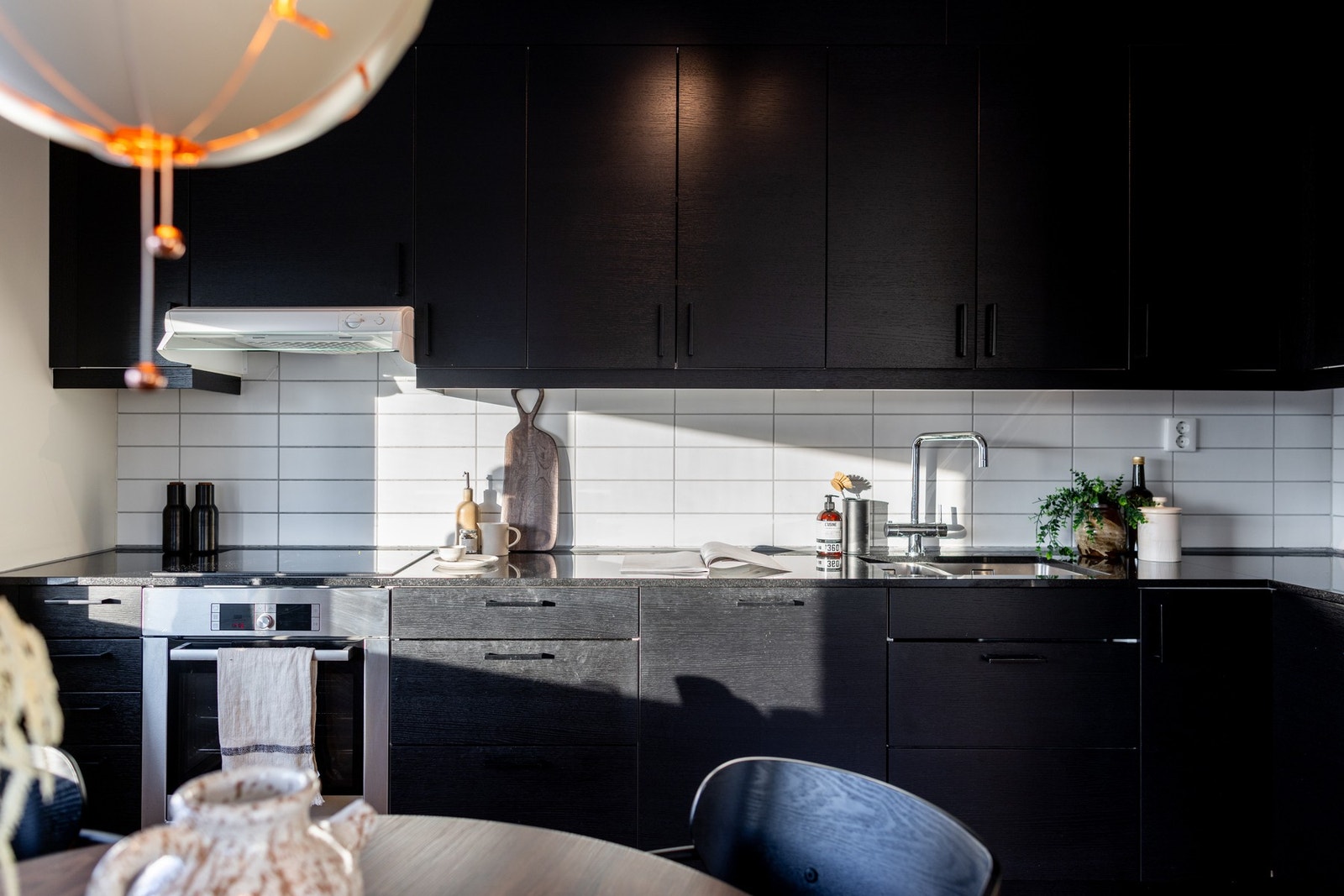 Glatte fronter i mørk utførelse er kombinert med benkeplate i granitt. Galleribilde