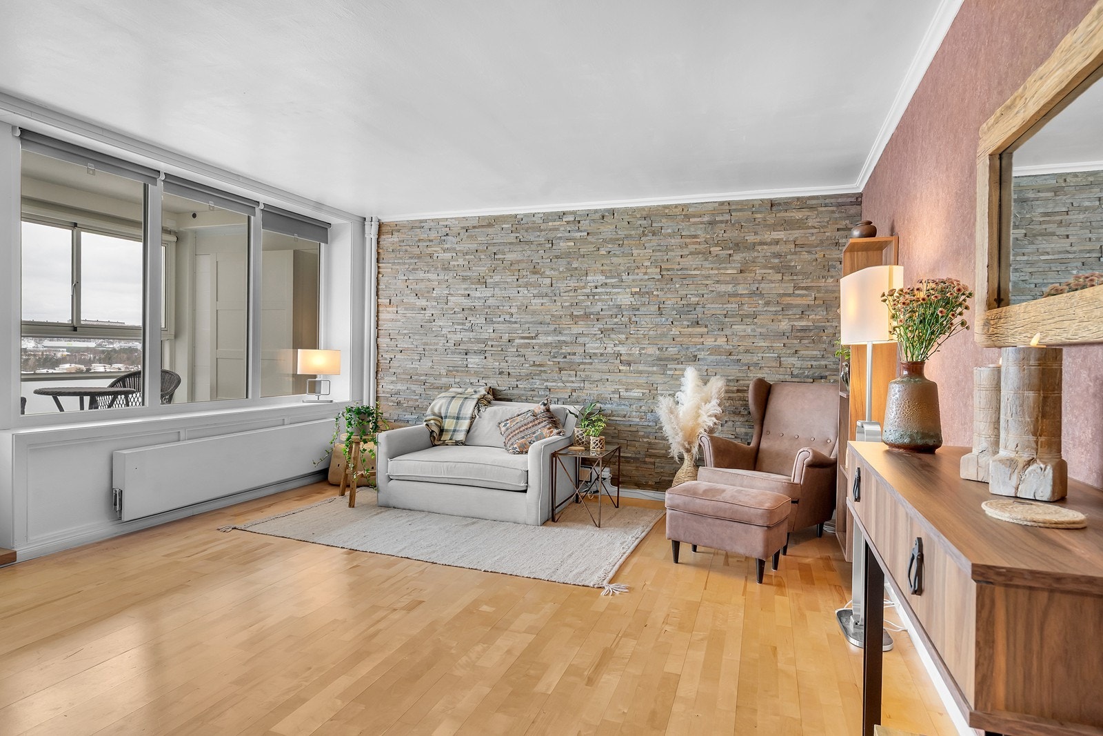 Romslig og lys stue med dekorativ fondvegg i naturstein og gode møbleringsmuligheter. Galleribilde