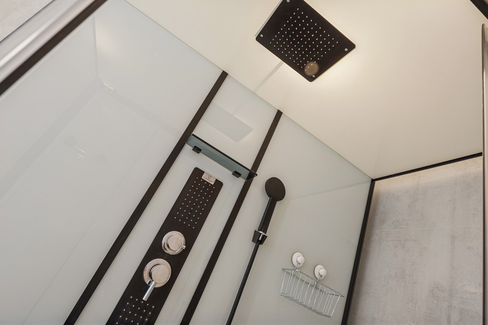 Dusjkabinett med svarte detaljer og moderne dusjhode for effektiv vannstrøm. Galleribilde