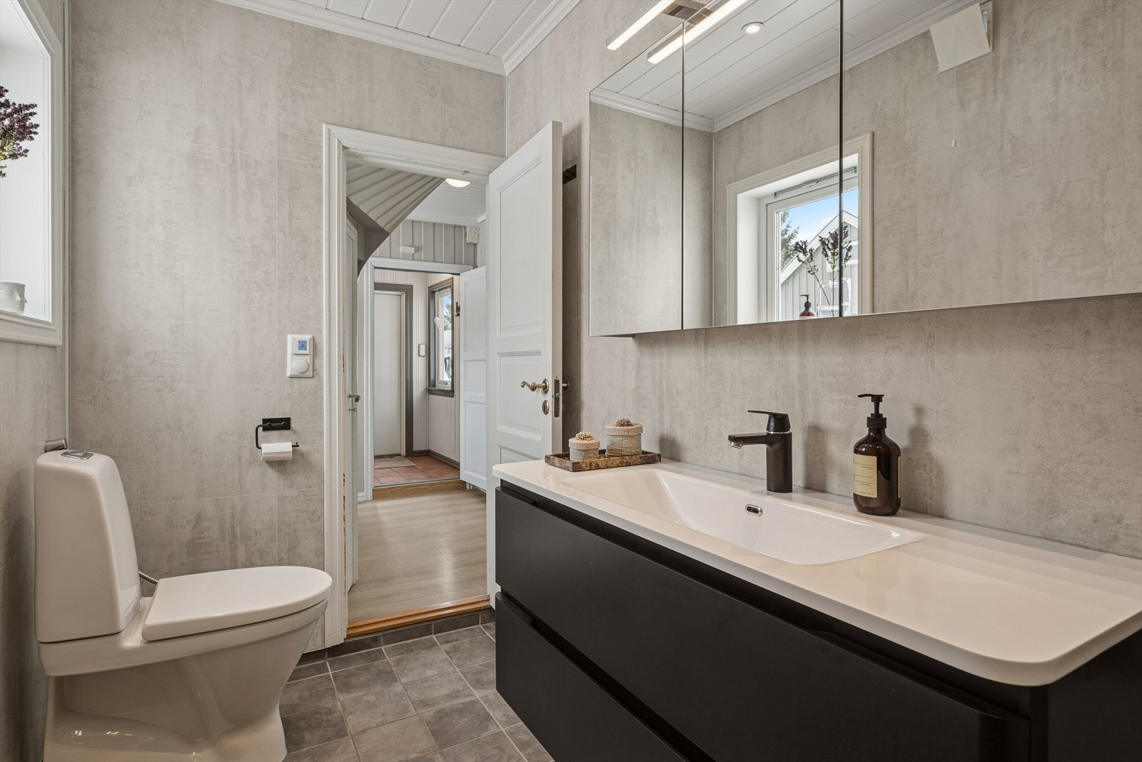 Her får du et praktisk rom med dusjkabinett, speilskap og gulvmontert toalett. Galleribilde