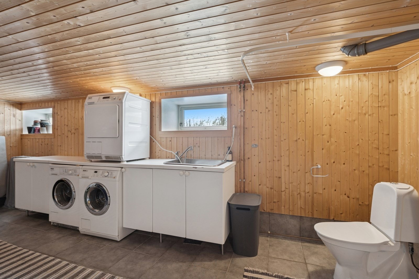 Kjelleren rommer gode lagrings- og oppbevaringsmuligheter, samt et praktisk vaskerom. Merk at rommene i kjelleren ikke inngår i boligens målbare areal grunnet takhøyde under 190 cm. Galleribilde