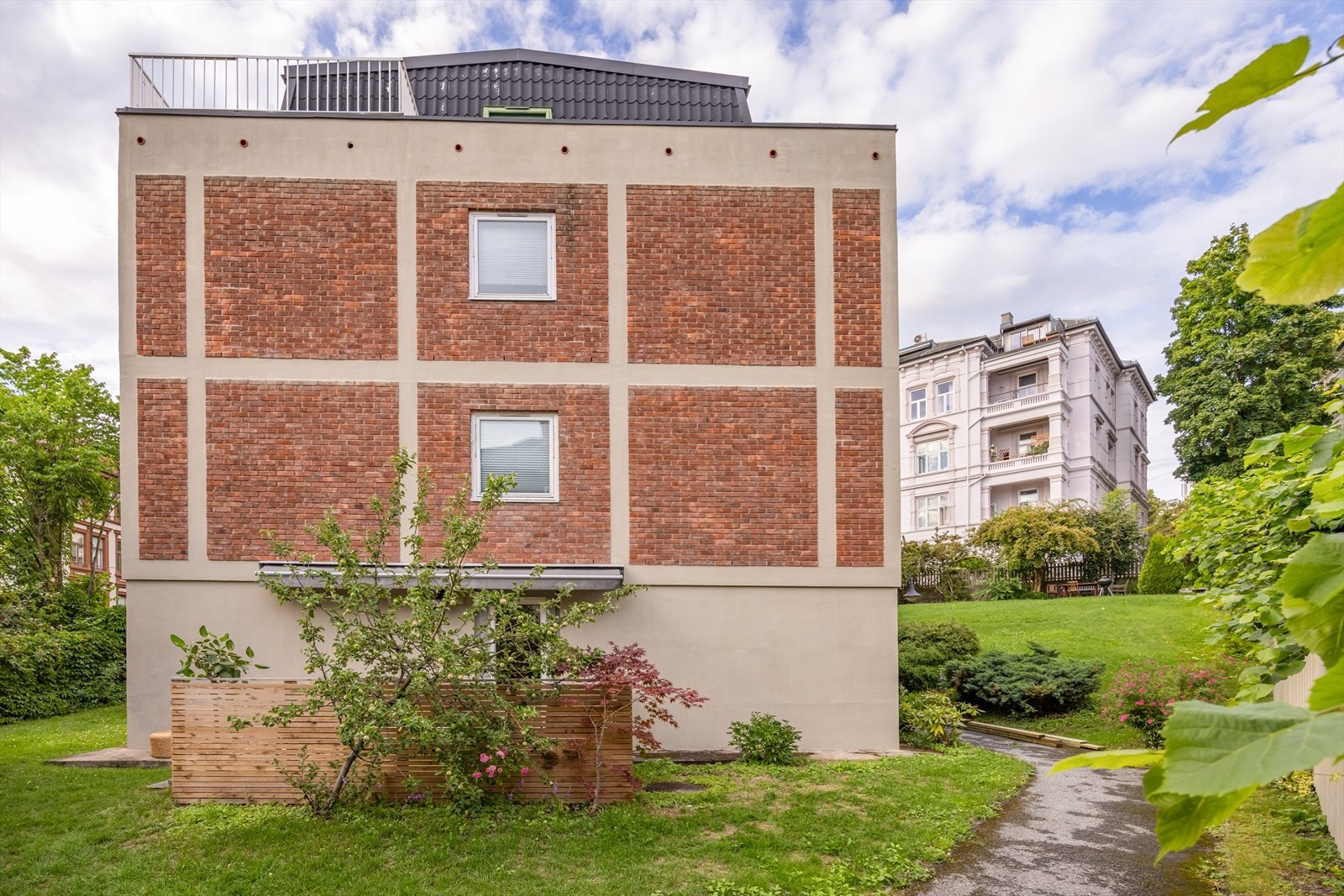 Sameiets gårdsrom er pent opparbeidet med sittegrupper, plenarealer, beplantning og blomsterbed, og fremstår stille og solrikt. Galleribilde