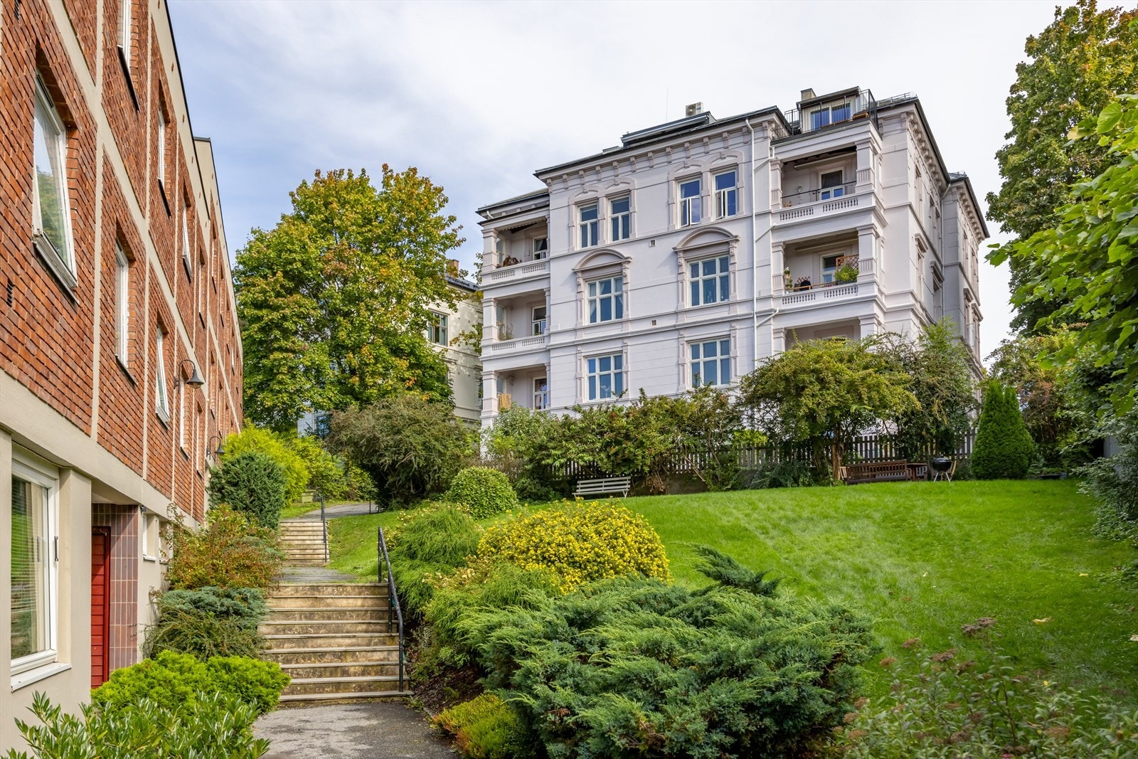 Meget pent opparbeidet og beplantet gårdsrom med sittegruppe. Store plenarealer, prydbusker, hekk, blomsterbed. Stille og fredelig med gode solforhold. Galleribilde