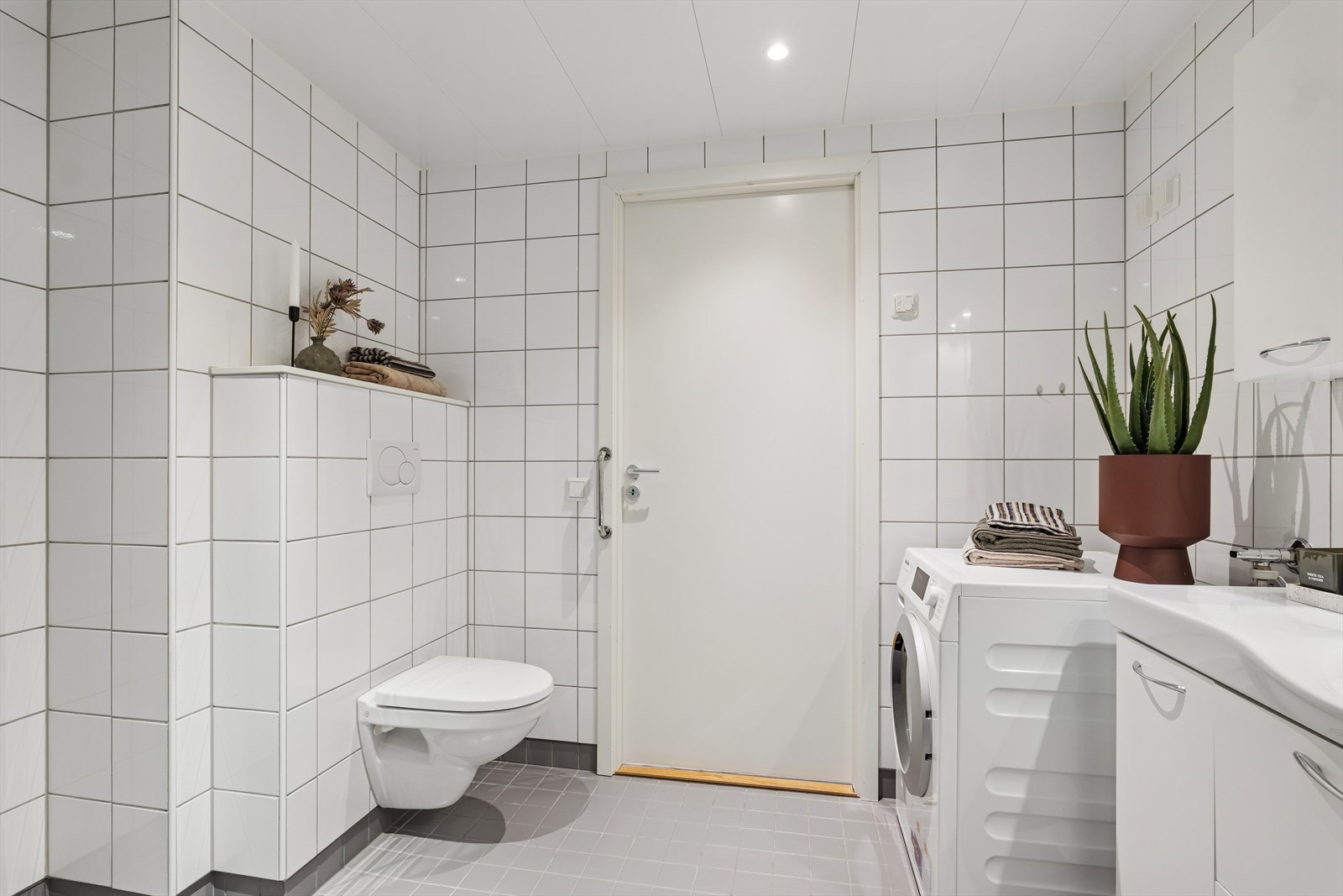 Badet har baderomsinnredning, vegghengt wc, dusjhjørne og downlights i tak. Galleribilde