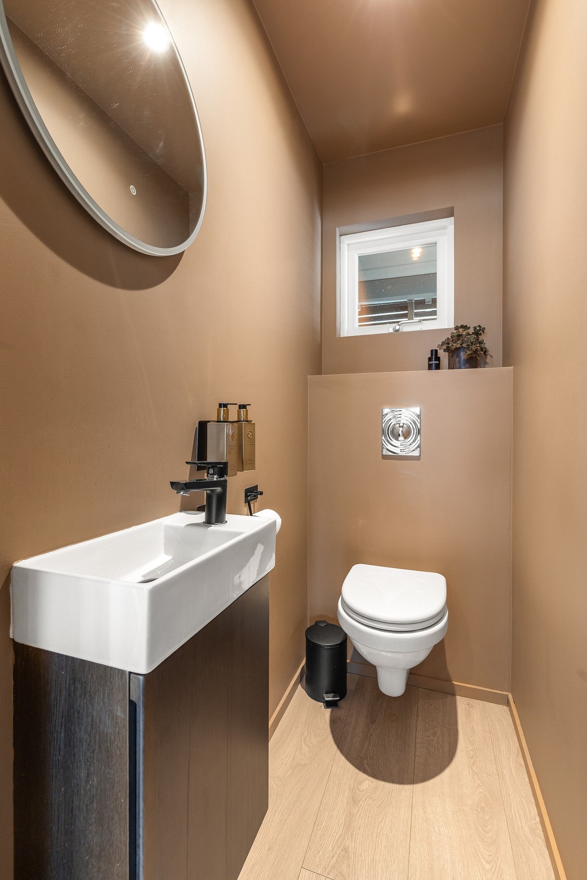 Toalettrom med vegghengt toalett og servantskap. Det er montert varmefolie i gulv. Galleribilde