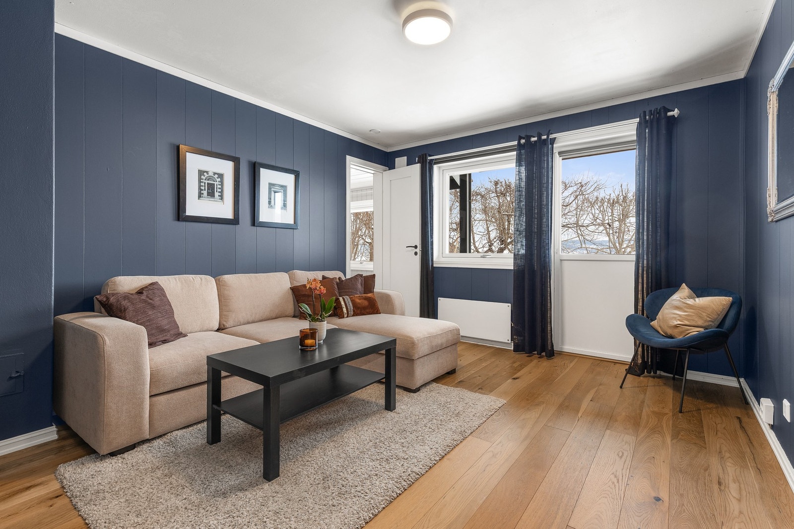 Stue i u. etasje med 1-stavs parkettgulv og panel på vegger. direkte utgang til terrasse. Galleribilde